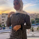 بنت مصرية عشرينية قدام المراية بتاخد صورة نودز وهي بتبتسم للكاميرا